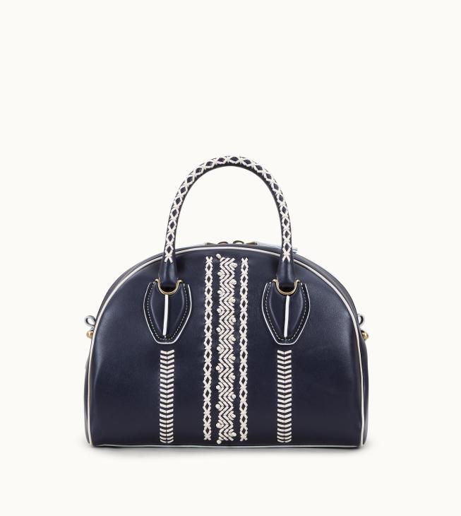Navy handbag with white geometric hand-stitching detail and patterned handles