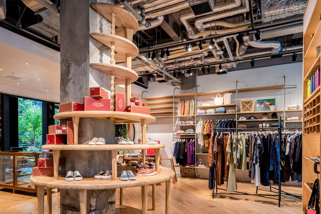 Interior of Pilgrim Surf + Supply Kyoto store with white oak furniture and wooden display tables.