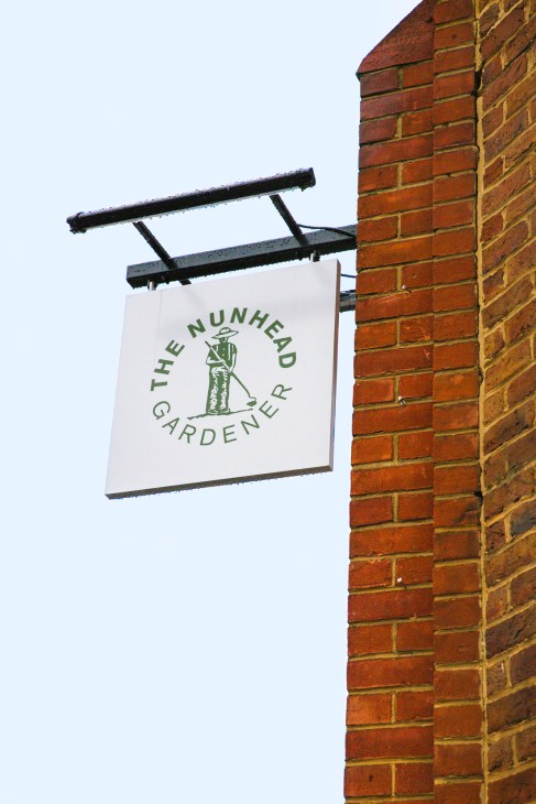 The Nunhead Gardener shop sign hanging on a brick building exterior.