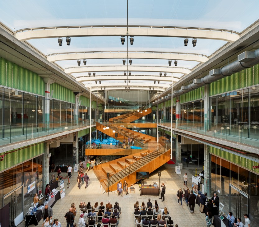 Interior atrium of Post Houston with orange zigzag staircase and people gathered below