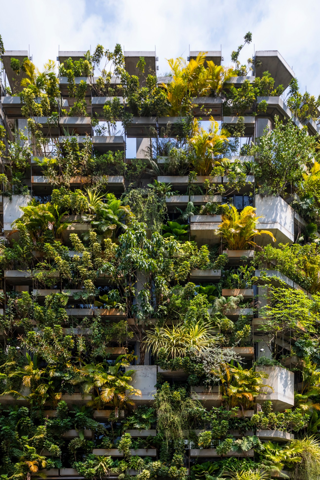 Urban Farming Office building by VTN Architects with lush vertical gardens covering concrete facade