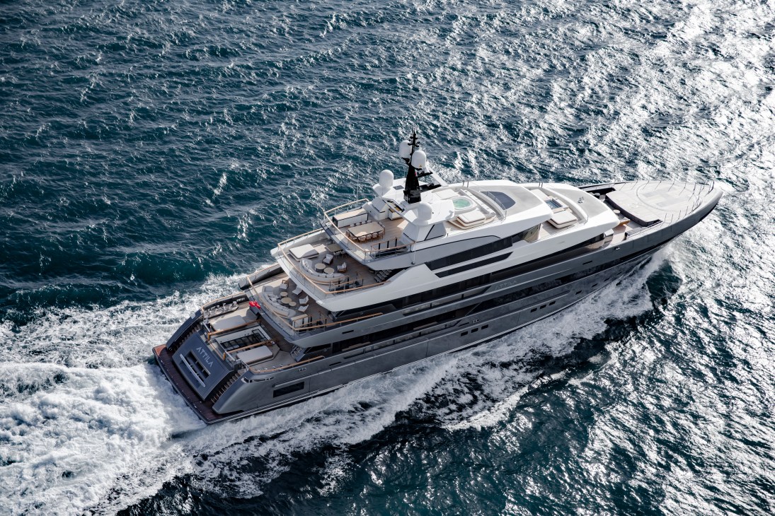 Large luxury yacht cruising through choppy ocean waters creating white wake trails