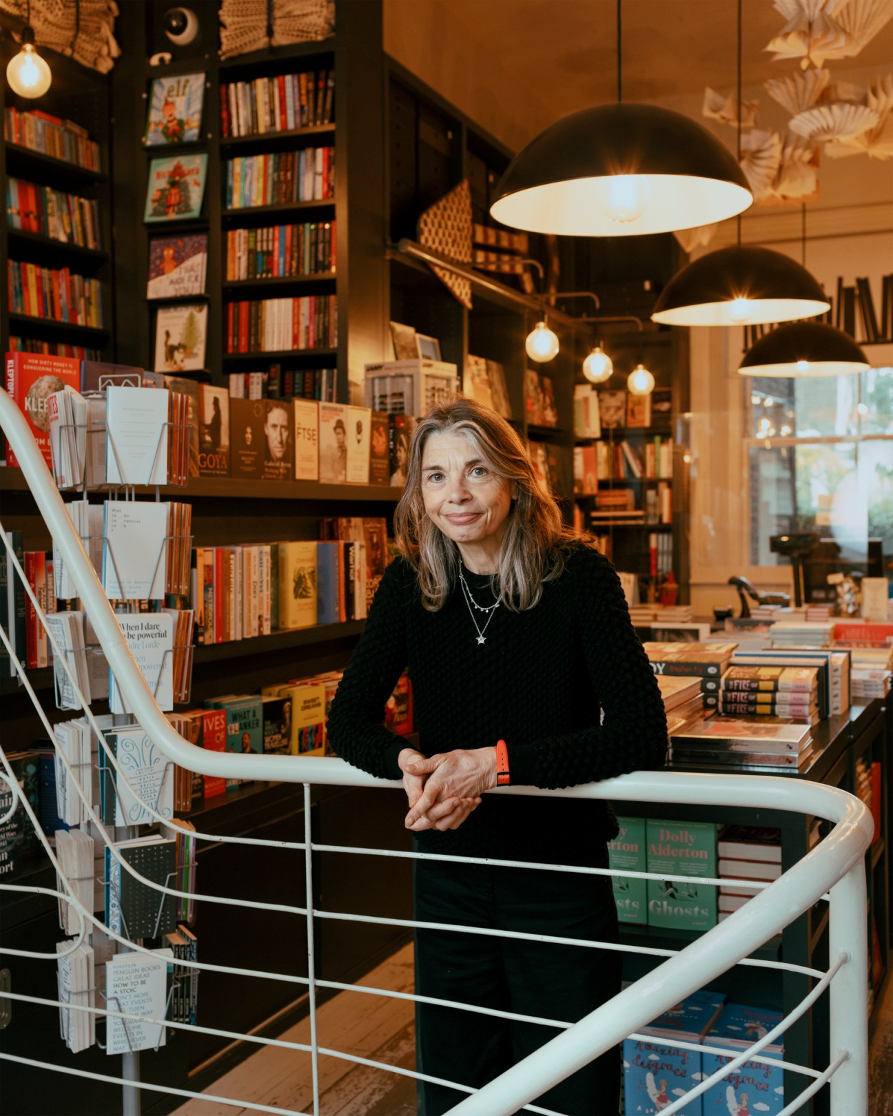 Claire Harris of Lutyens & Rubinstein standing in her bookshop surrounded by shelves of books