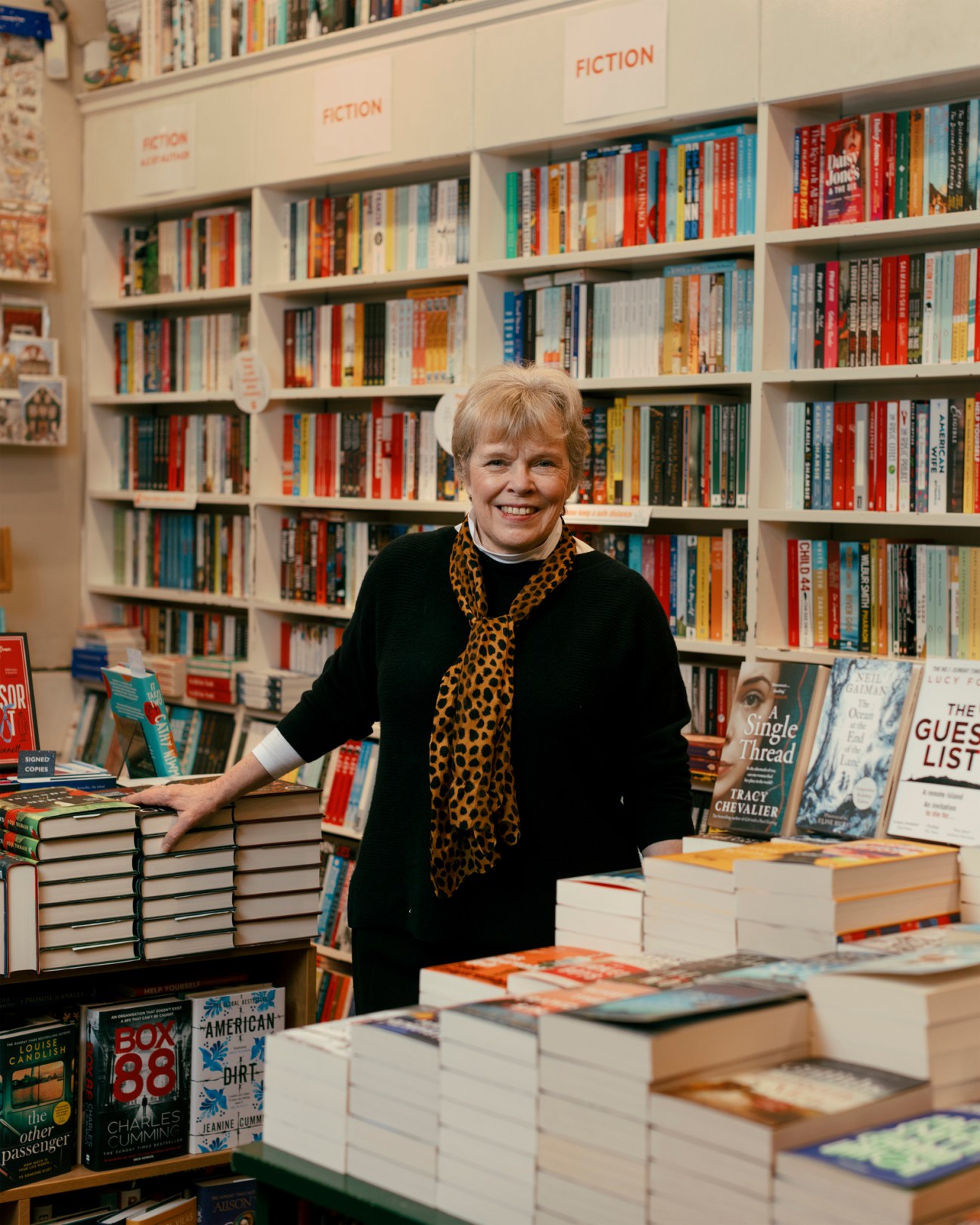Portrait of Hazel Broadfoot in her village bookshop with books visible in the background
