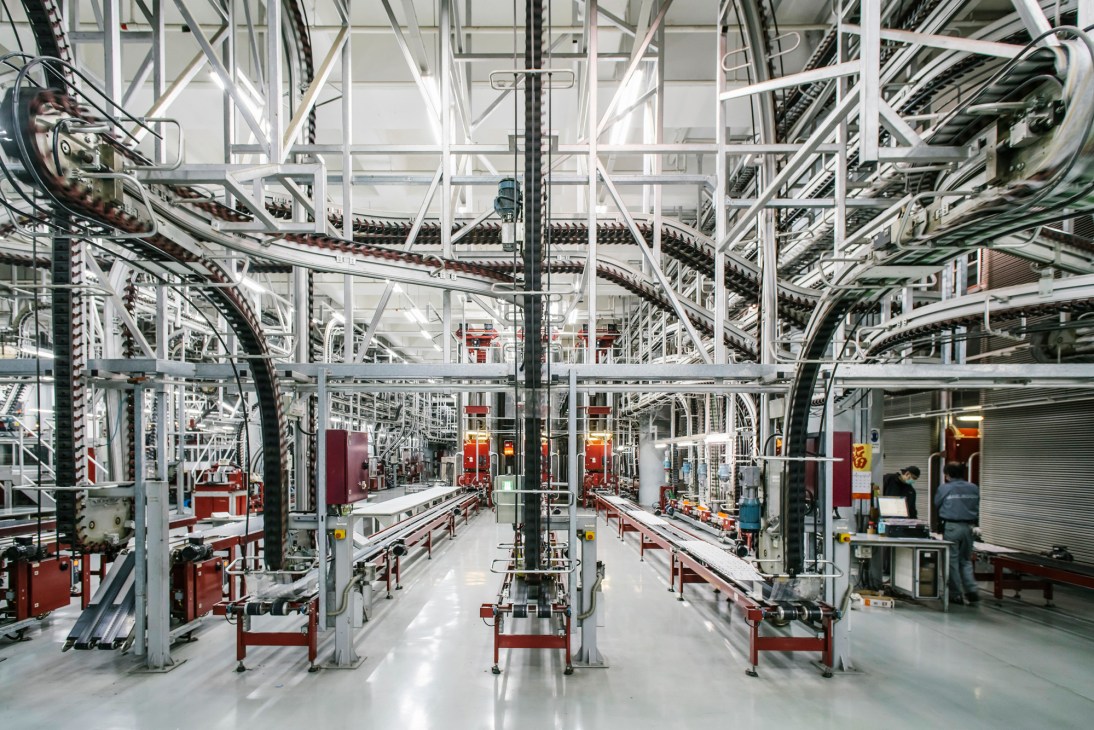 Industrial printing facility with white metal framework, conveyor systems, and red machinery components