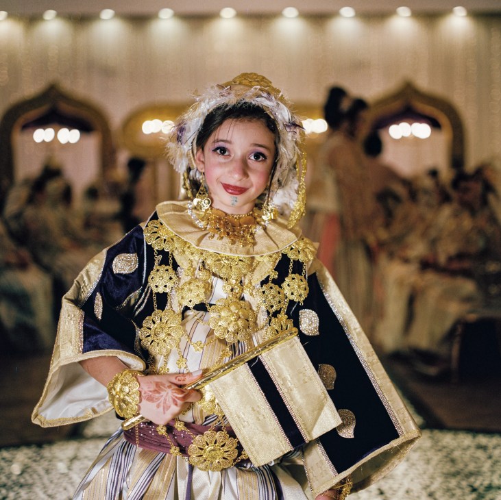 Young woman in elaborate traditional Libyan wedding dress with gold embroidery, ornate jewelry and decorative headpiece