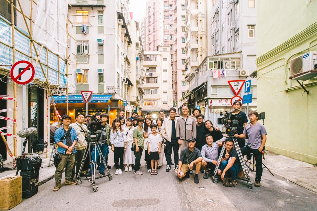 Film crew with cameras and equipment wrapping up production on outdoor street location