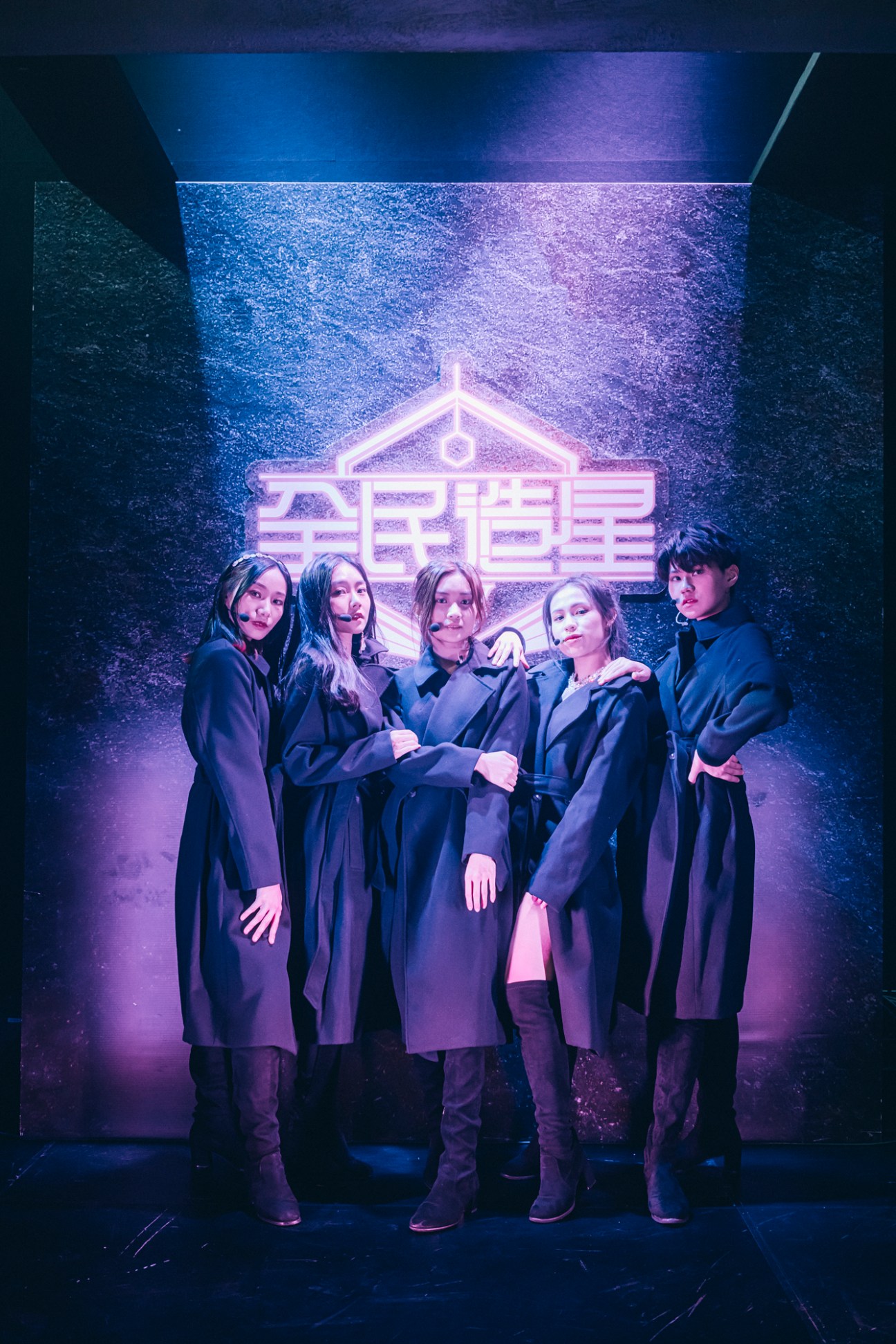 Five contestants in dark robes posing together backstage under purple lighting for King Maker television show
