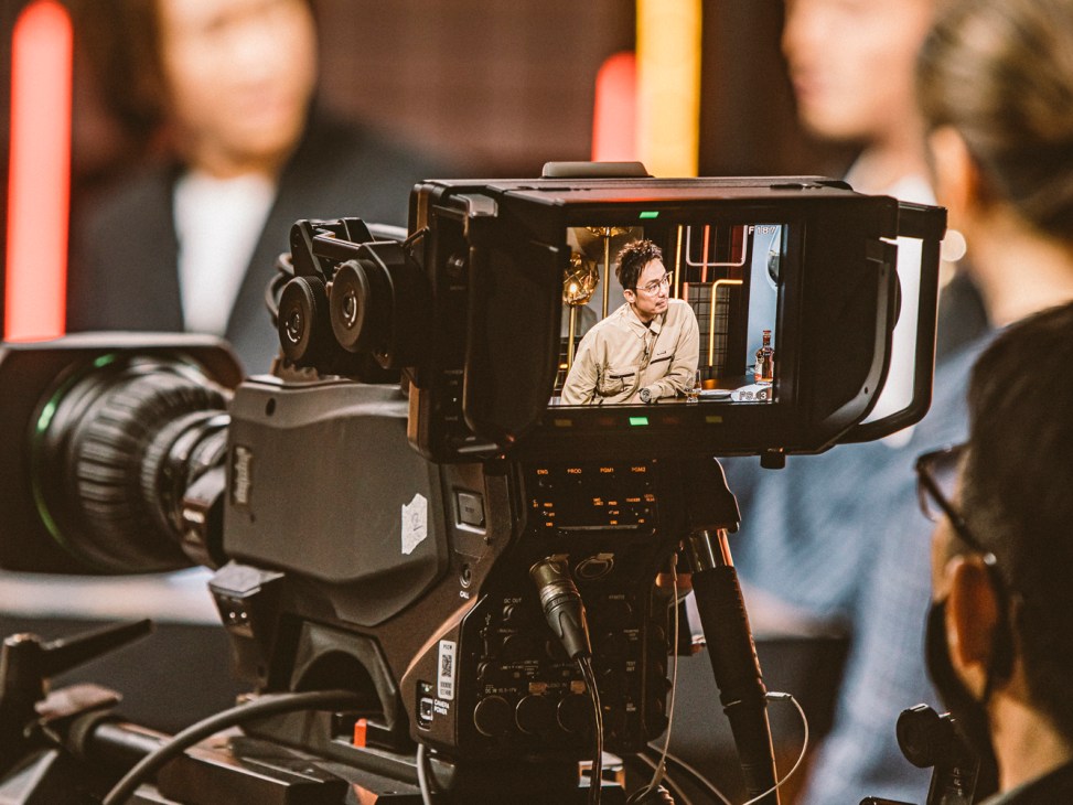 Professional television camera displaying monitor screen showing presenter during filming of ViuTV food talk show