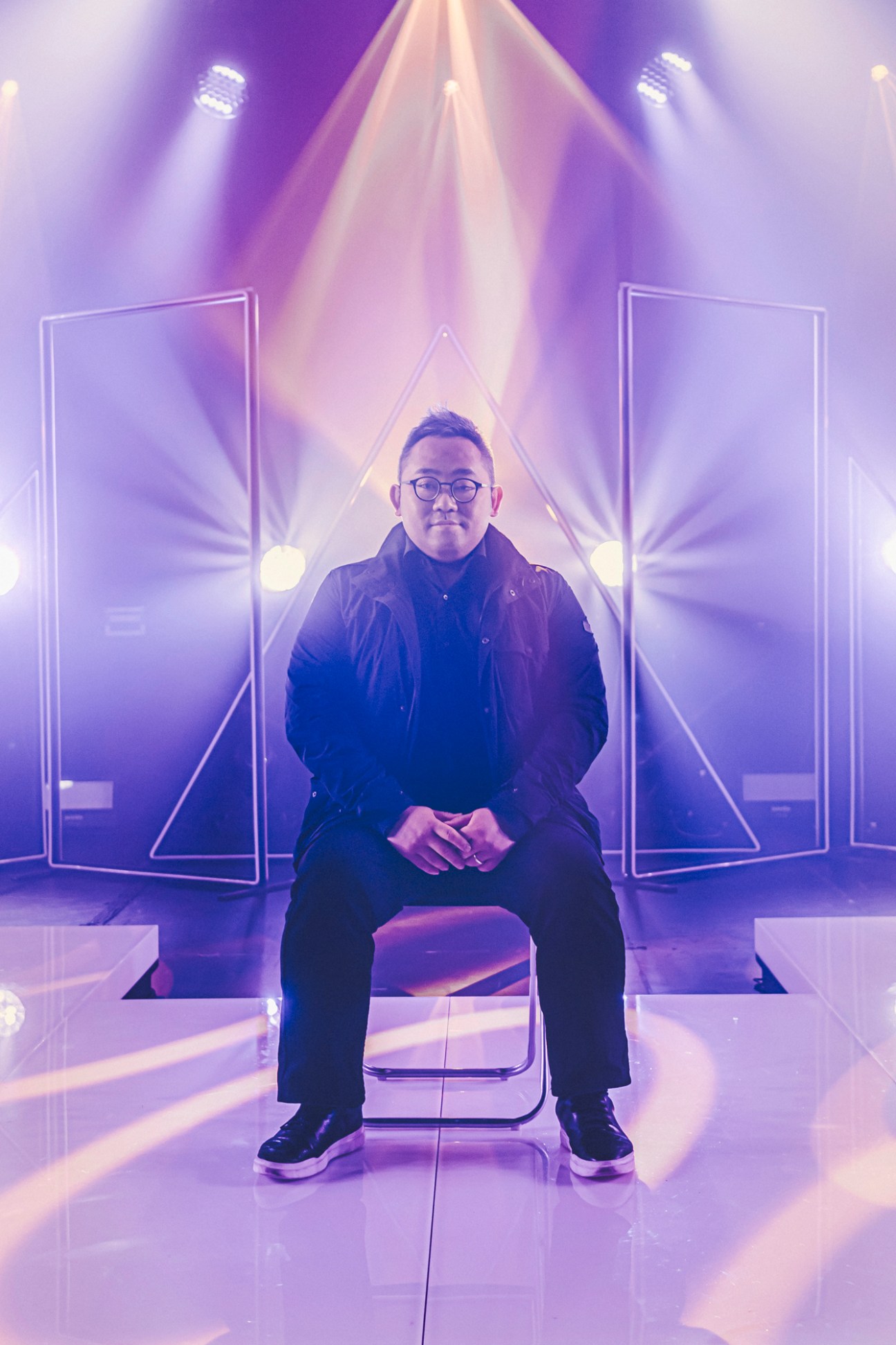 ViuTV head Lofai Lo sitting on chair in television studio with dramatic purple lighting and geometric stage design