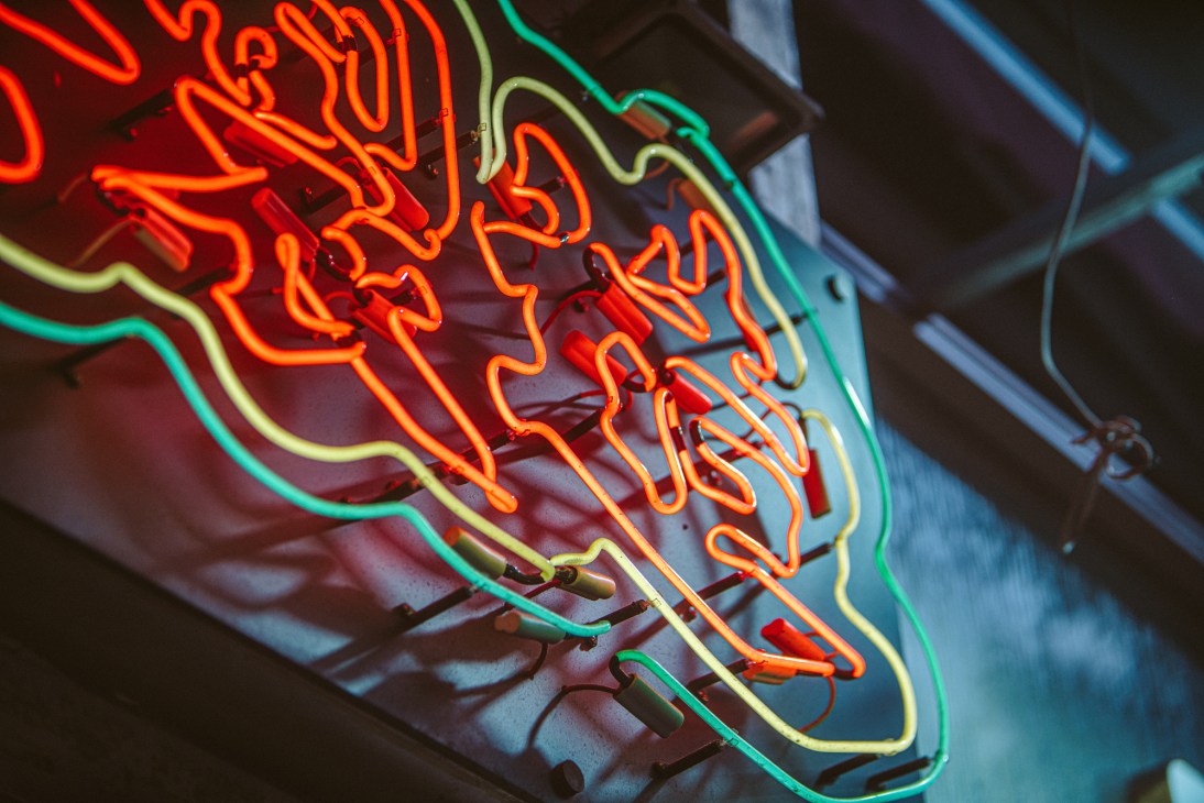 Modern heritage preservation workshop with traditional neon sign being restored