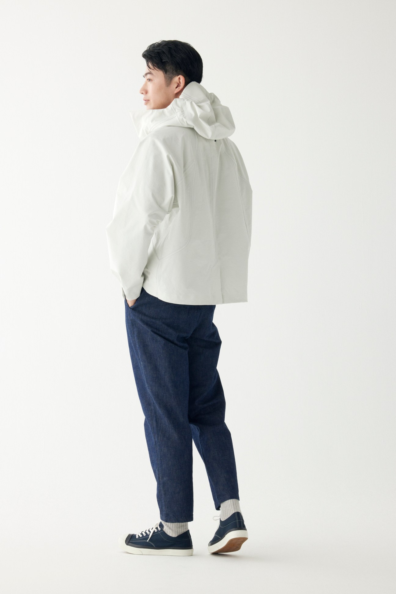 Man in technical jacket with relaxed trousers and white trainers