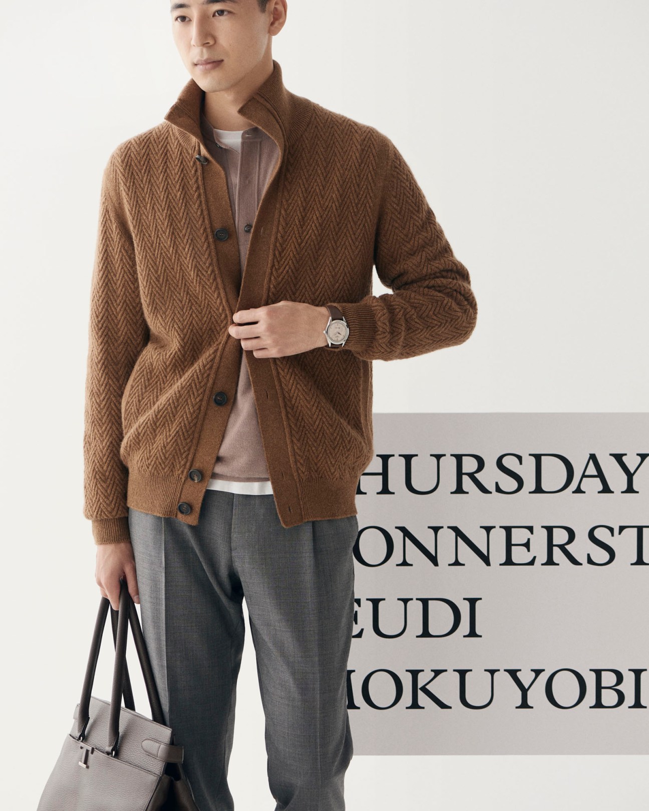Model wearing brown herringbone cardigan, beige shirt, white t-shirt, grey trousers with watch and leather bag