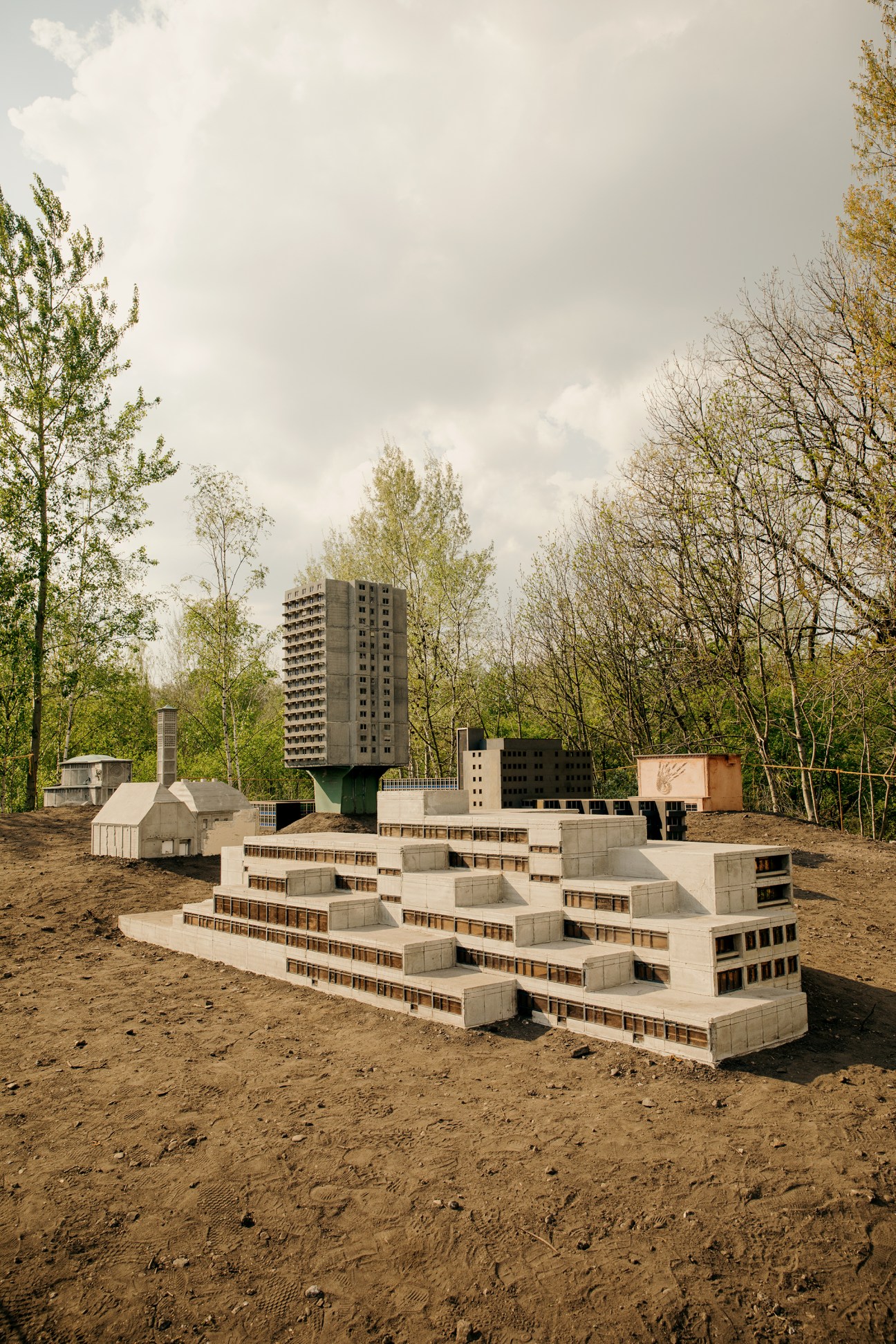 Miniature concrete building models under construction in a workshop setting