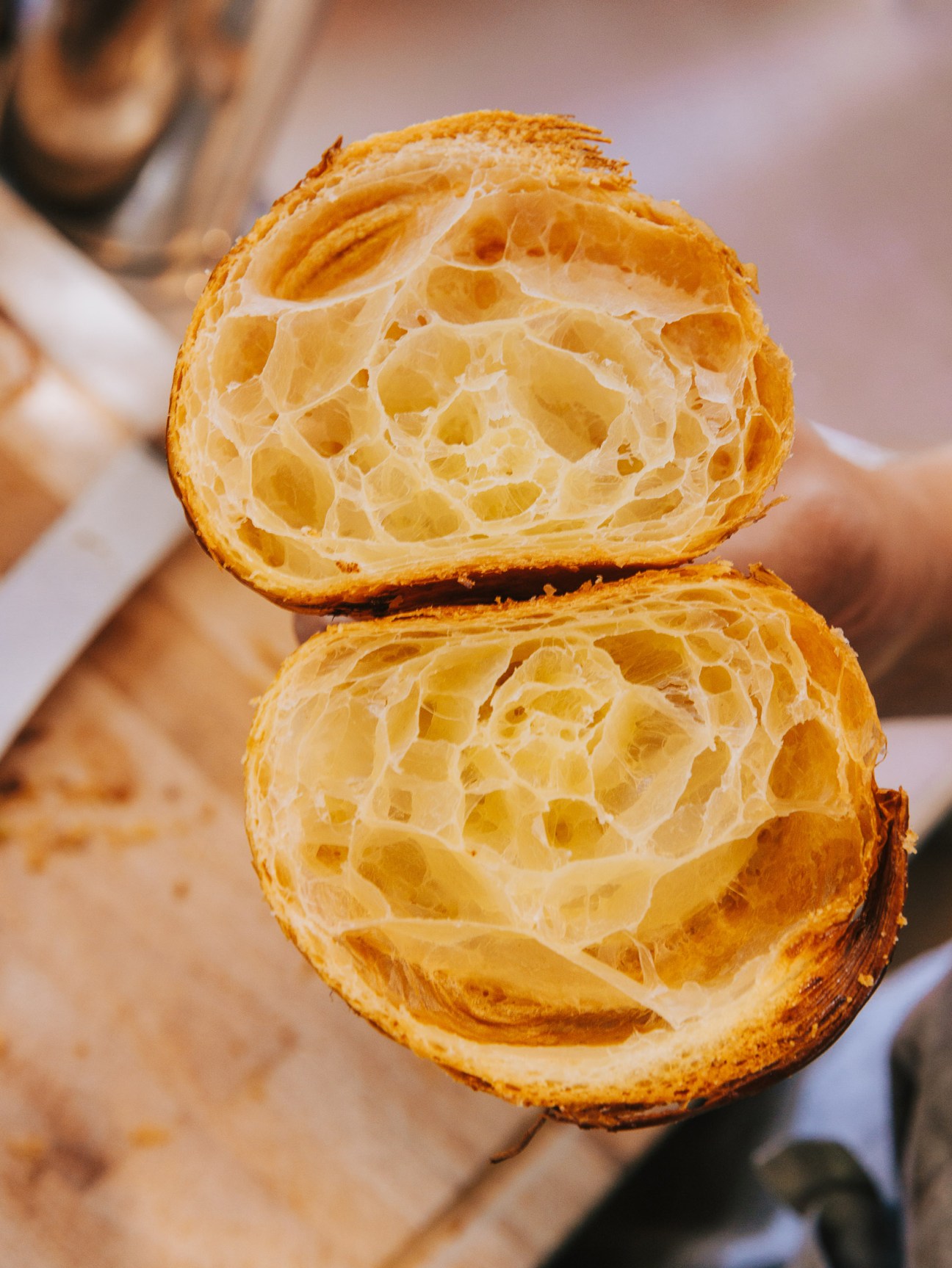 Cross-section of a flaky croissant showing laminated layers and air pockets from the butter and dough folding process