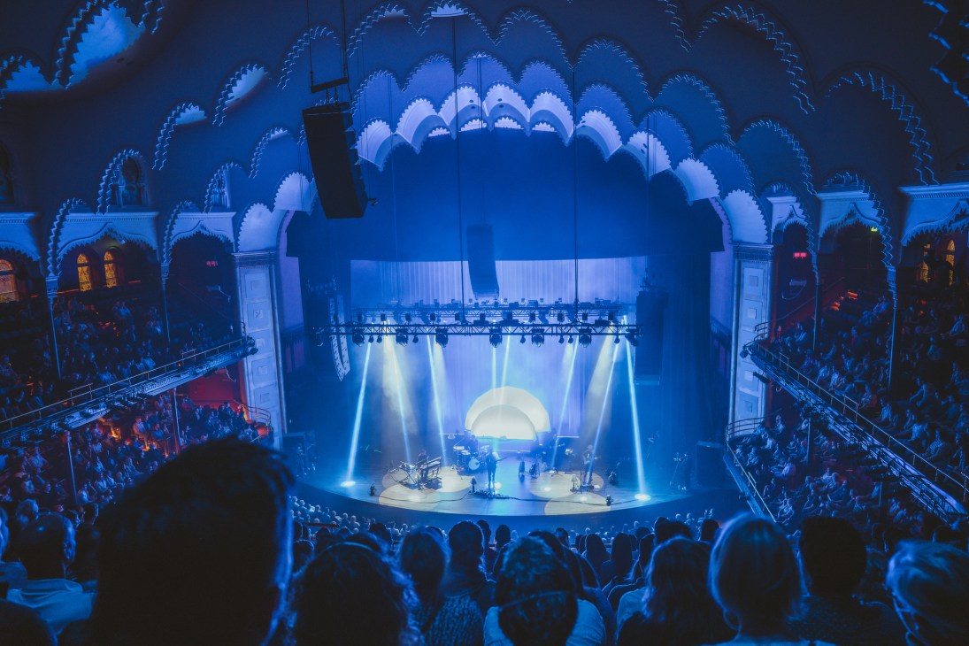 View from the upper balcony at Massey Hall showing stage with blue lighting and ornate architectural details