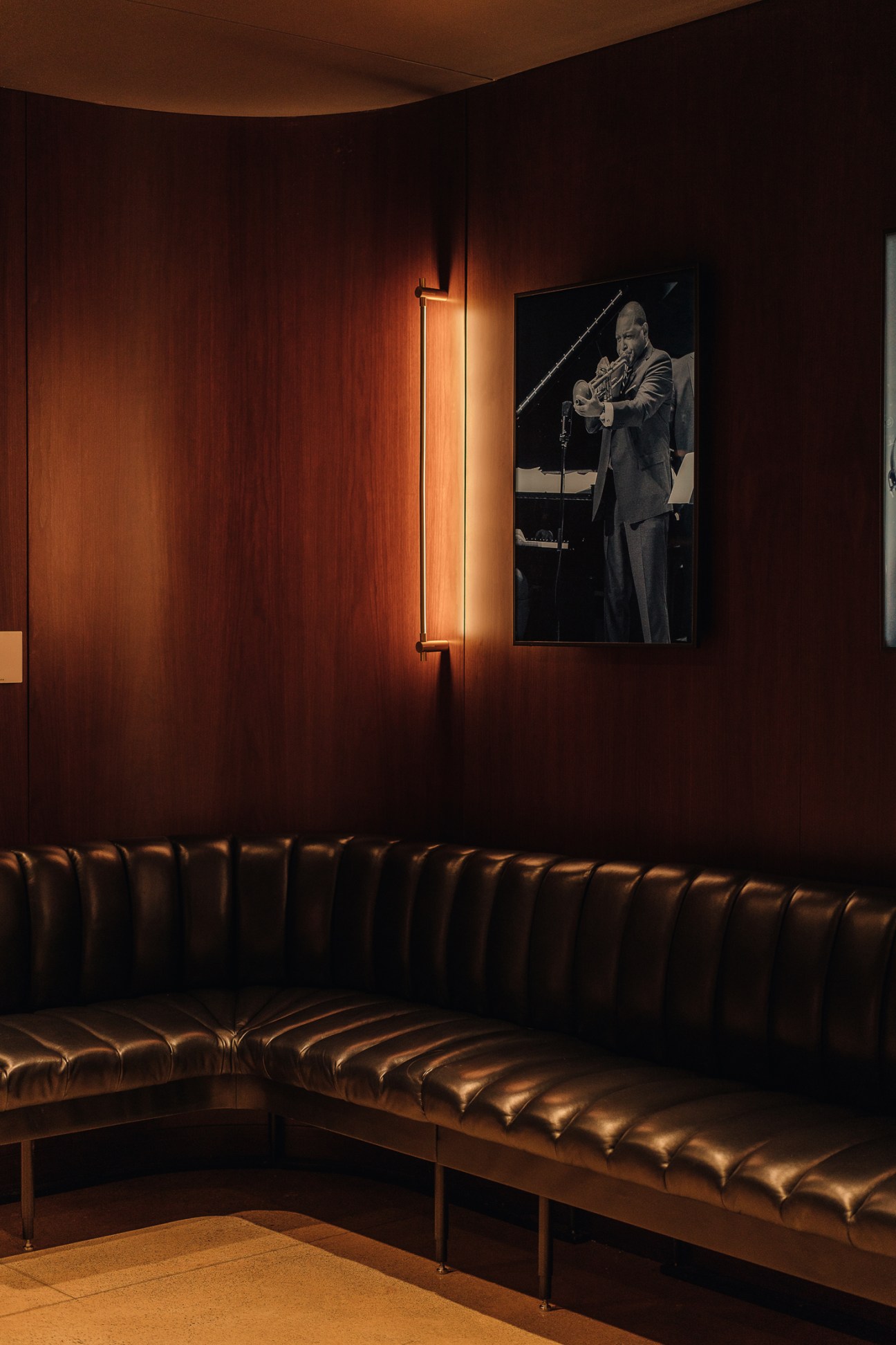 Portrait of Canadian jazz musician Oscar Peterson in black and white photograph on wood-paneled wall