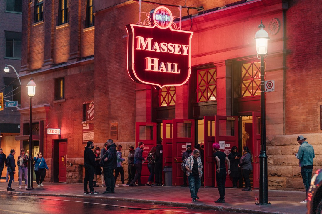 Attendees gathering outside Massey Hall's red-lit entrance with illuminated signage