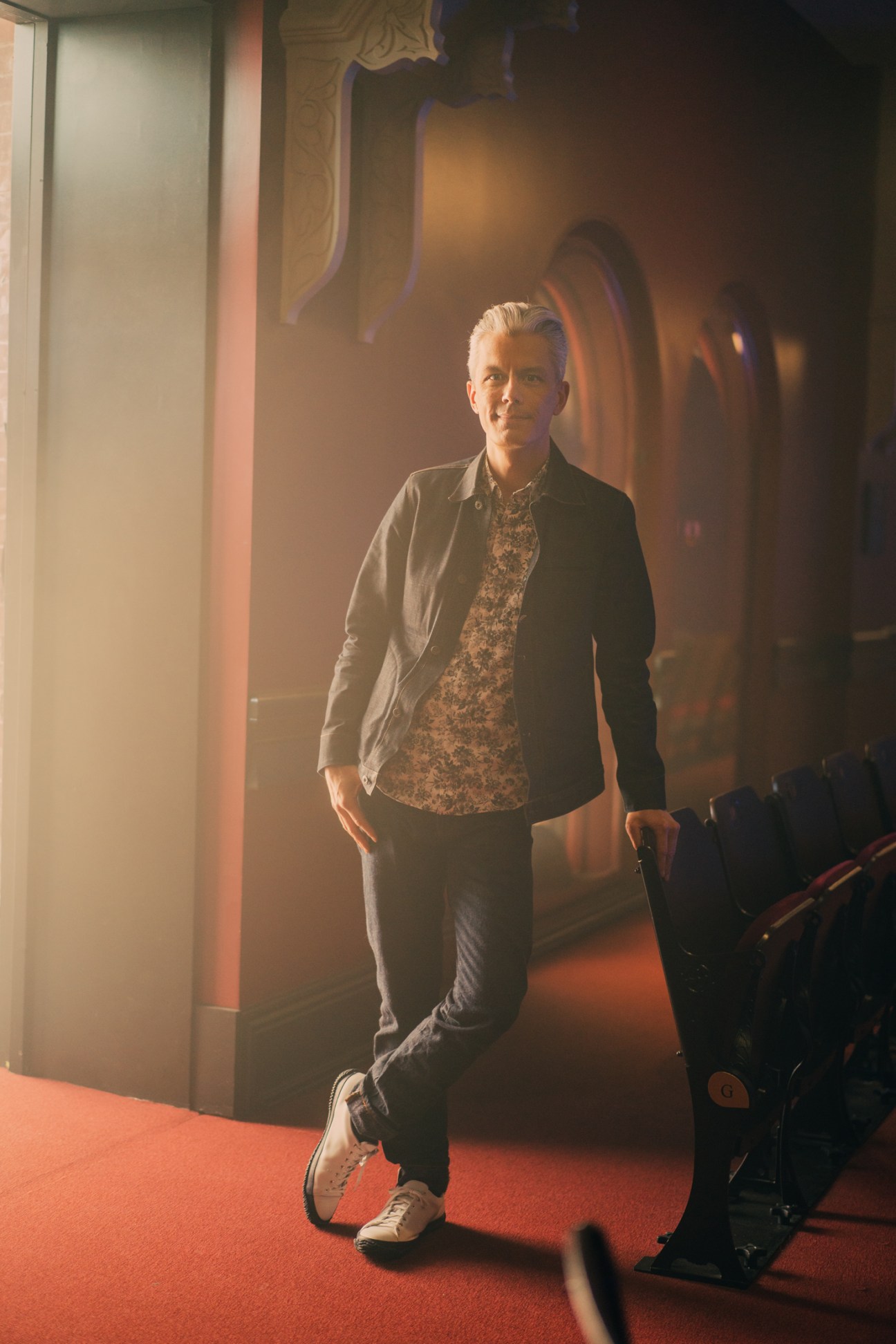 Jesse Kumagai, president and CEO of Massey Hall, standing on red carpet in venue entrance