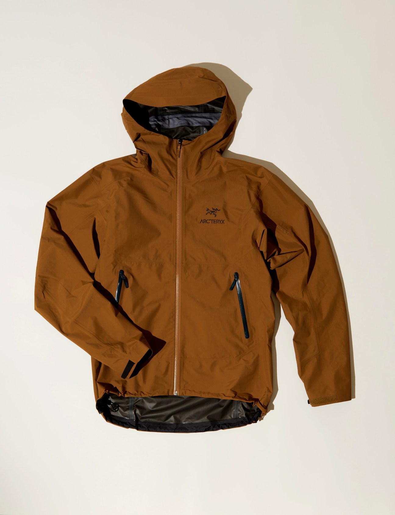 Arc'teryx Waterproof Zeta SL jacket in brown with hood and zippered pockets displayed against white background