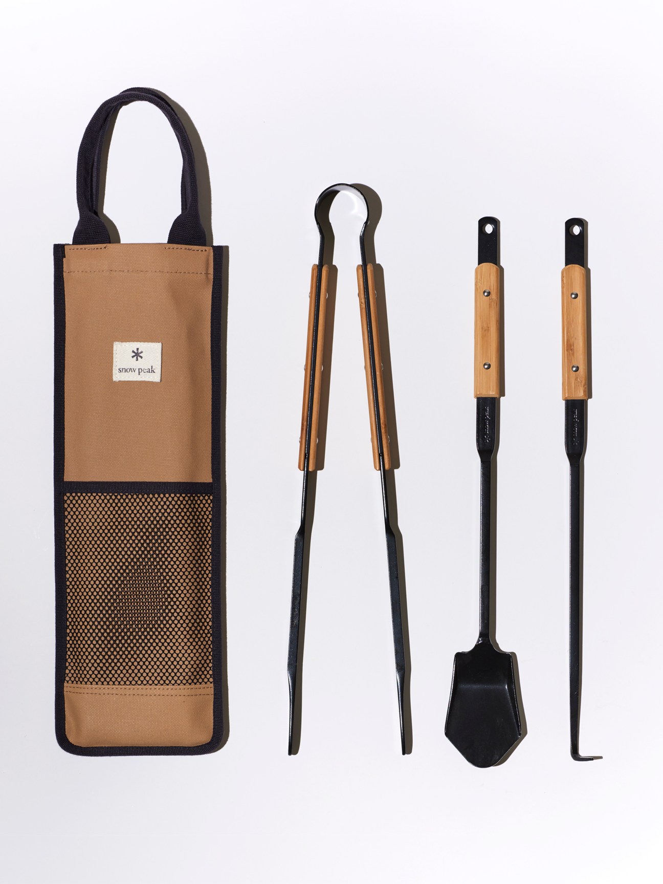 Snow Peak fire toolset with tan canvas carrying case, wooden-handled tongs and fireplace tools
