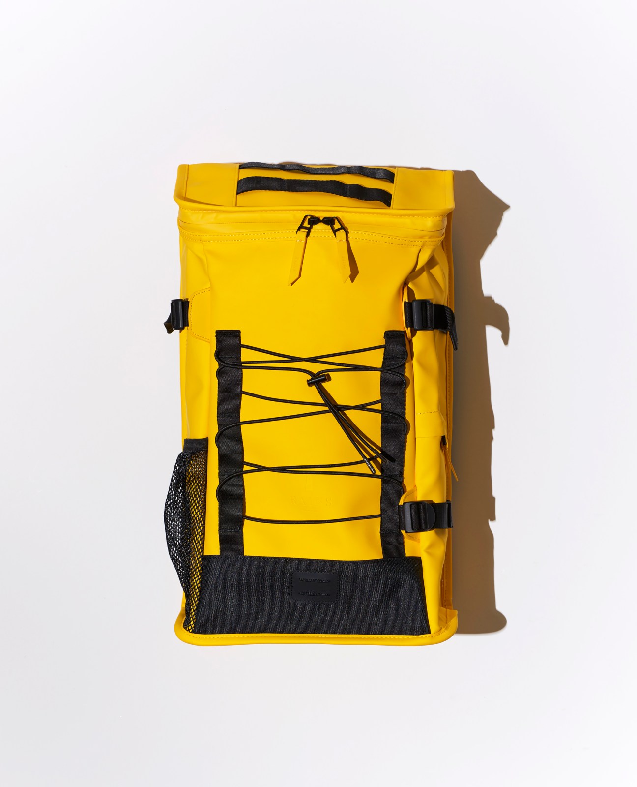 Yellow waterproof backpack with black straps and bungee cord system against white background