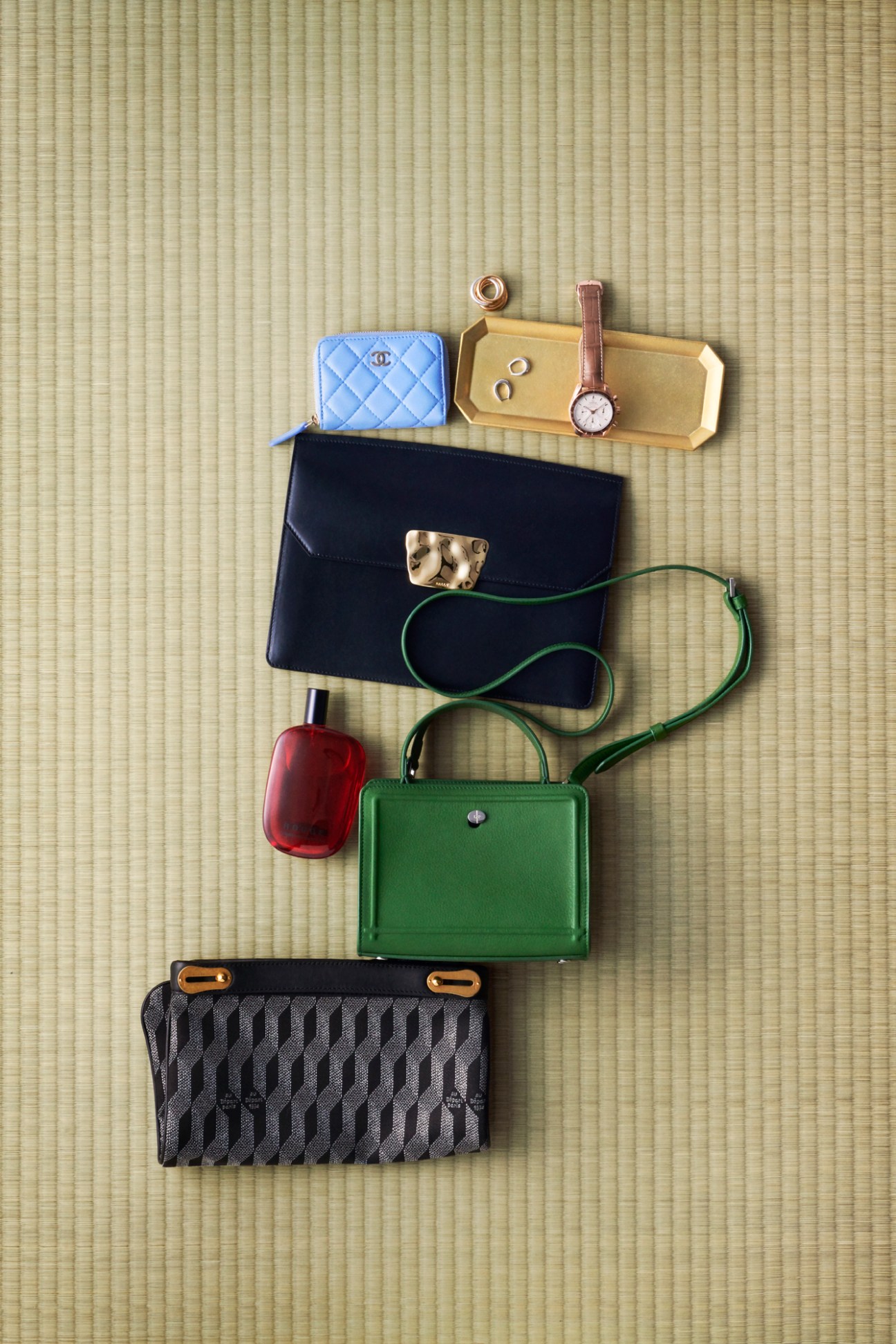 Luxury accessories arranged on tatami mat including Chanel coin purse, watches, bags, and jewelry