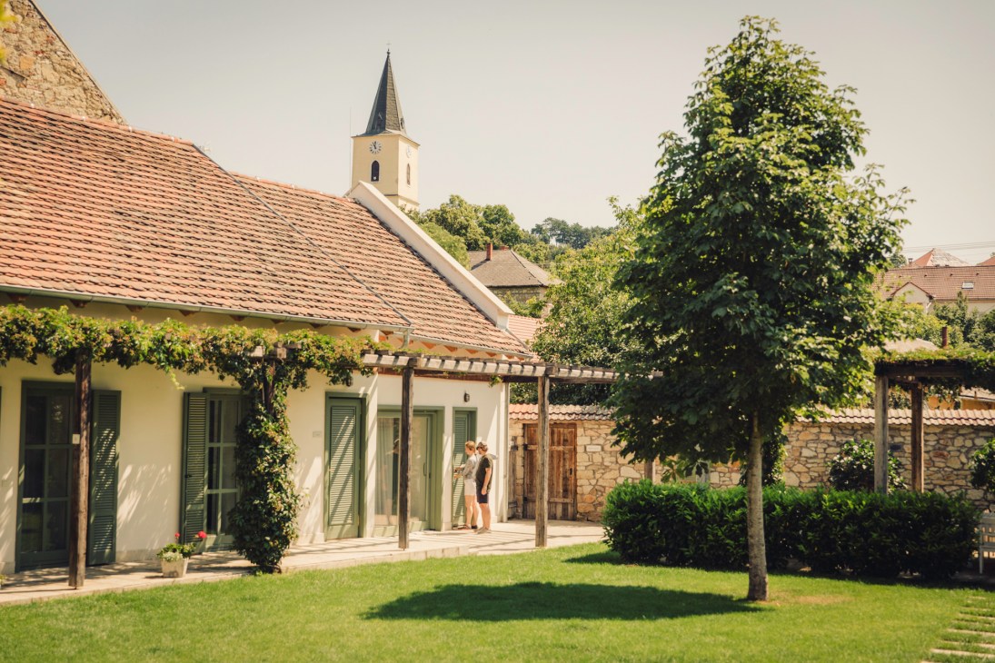Whitewashed Hotel R40 building with olive-green shutters and pergola in Mad village