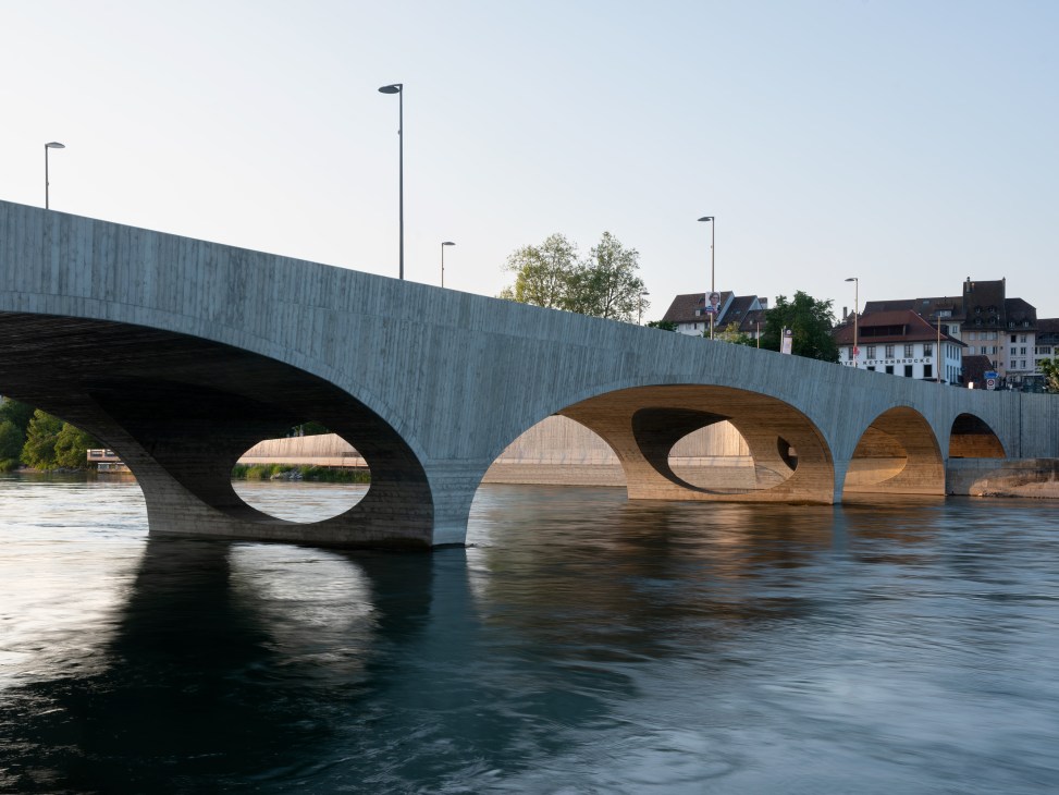 The New Aare Bridge in Aarau showing its elegant concrete arches spanning the river with glimpses of the waterway visible through openings beneath the deck