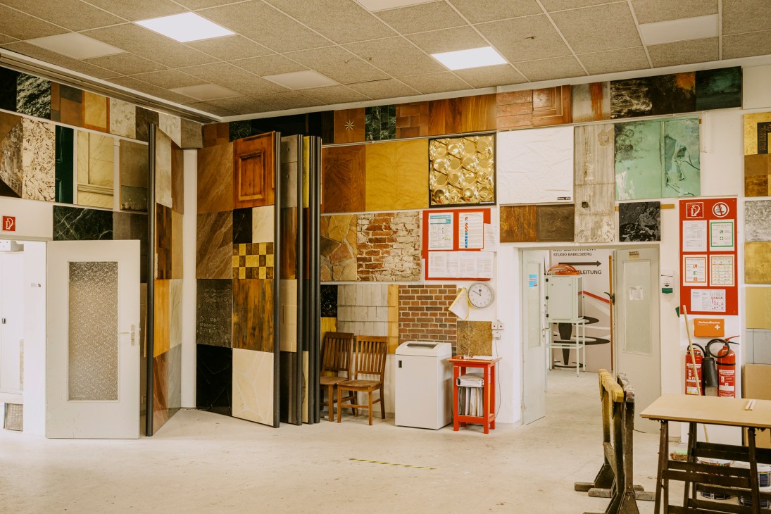 Paint workshop showing realistic surface recreations including faux parquet flooring and marble panelling samples