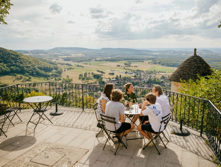 Group dining on a terrace with a sweeping valley view.