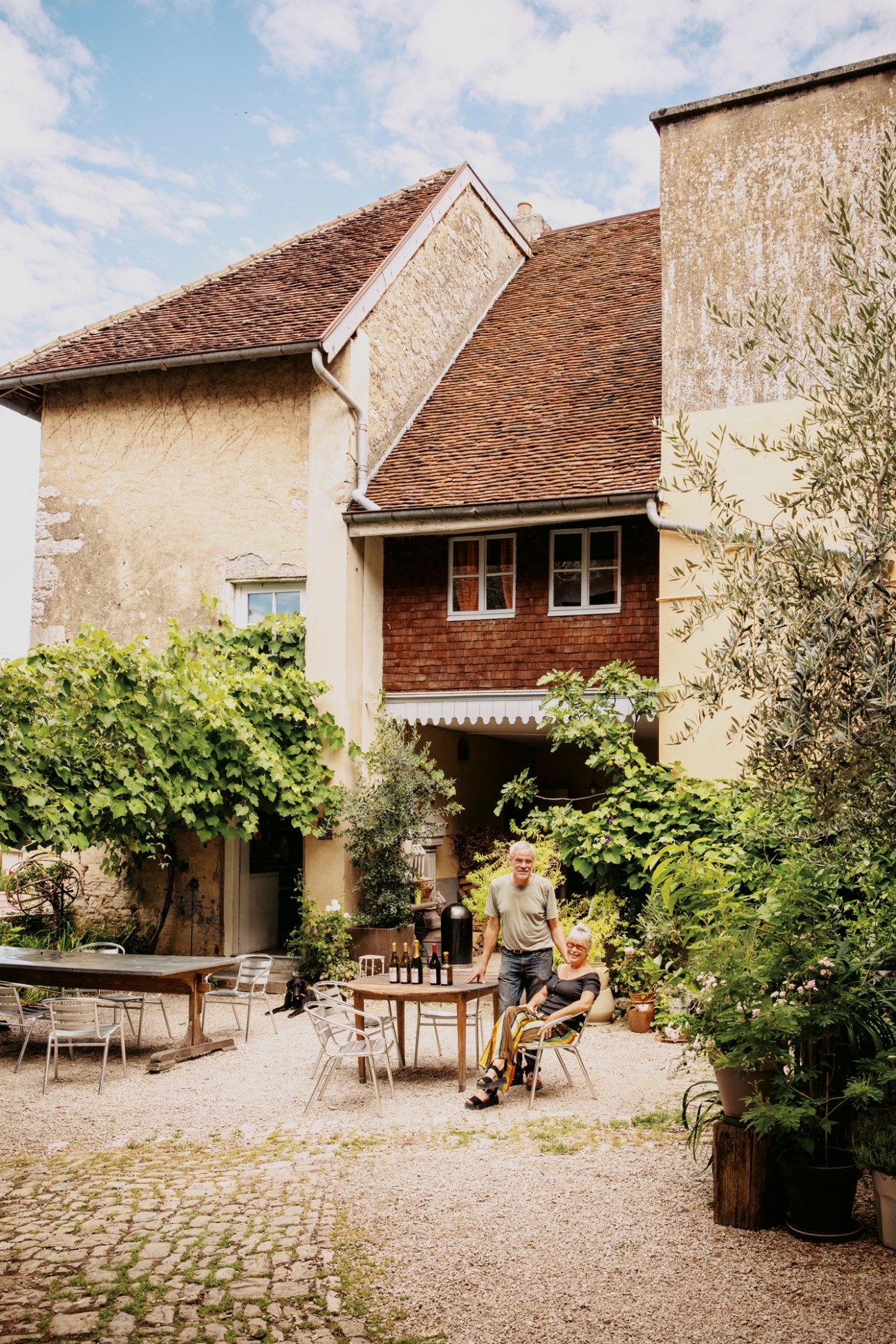 Ludwig Bindernagel and wife Nathalie standing outside their 17th-century stone house in Poligny