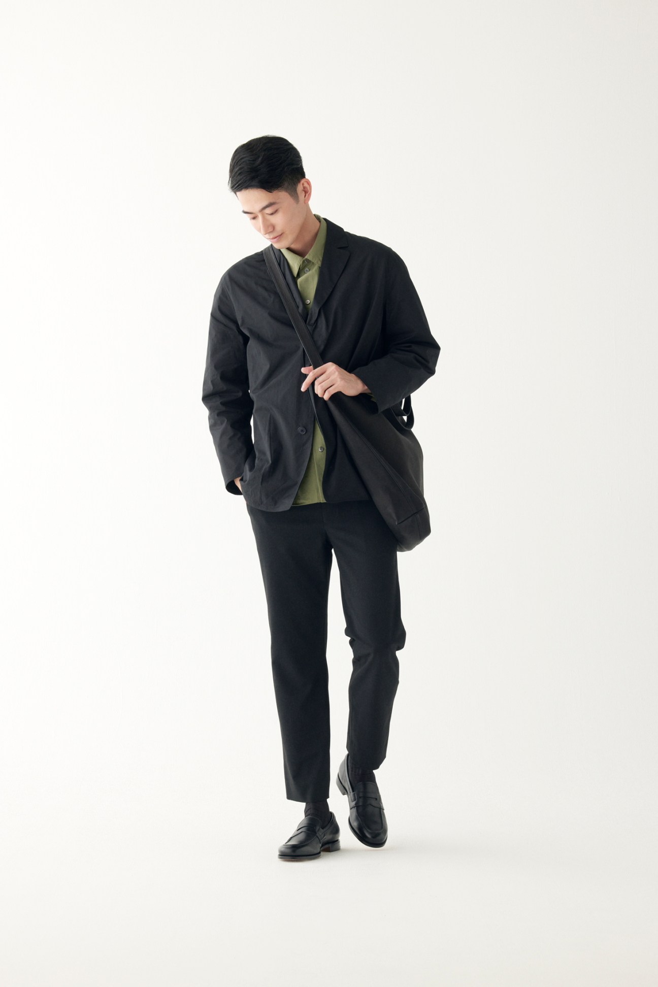Man in matching suit jacket and trousers with white shirt and leather shoes, carrying bag