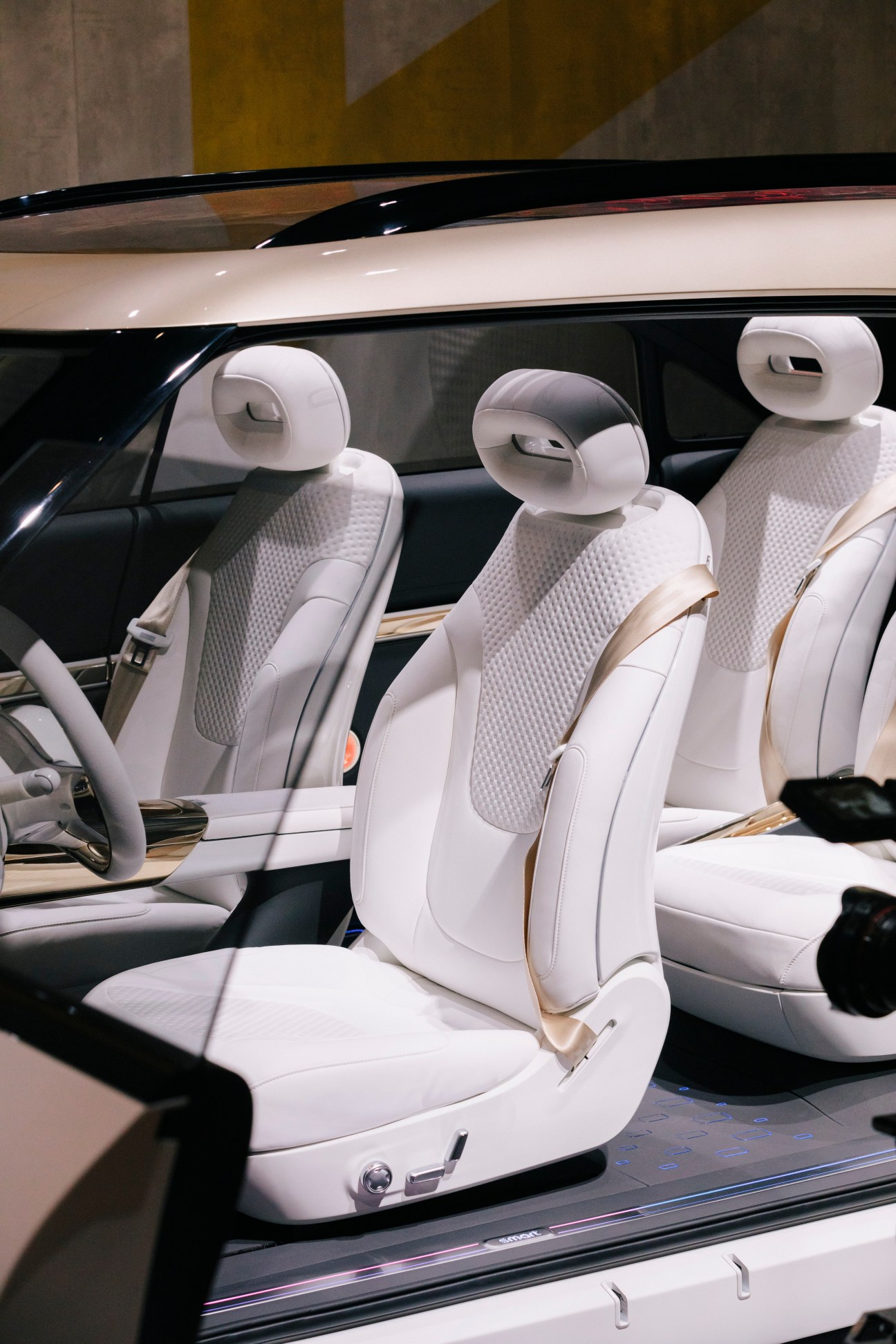 Interior view of a luxury car with white leather seats and modern headrests