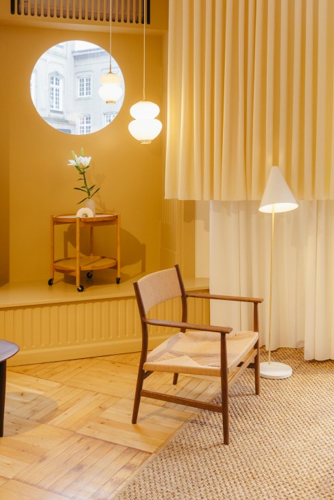 Brdr Krüger's ARV lounge chair displayed in warm wooden interior setting