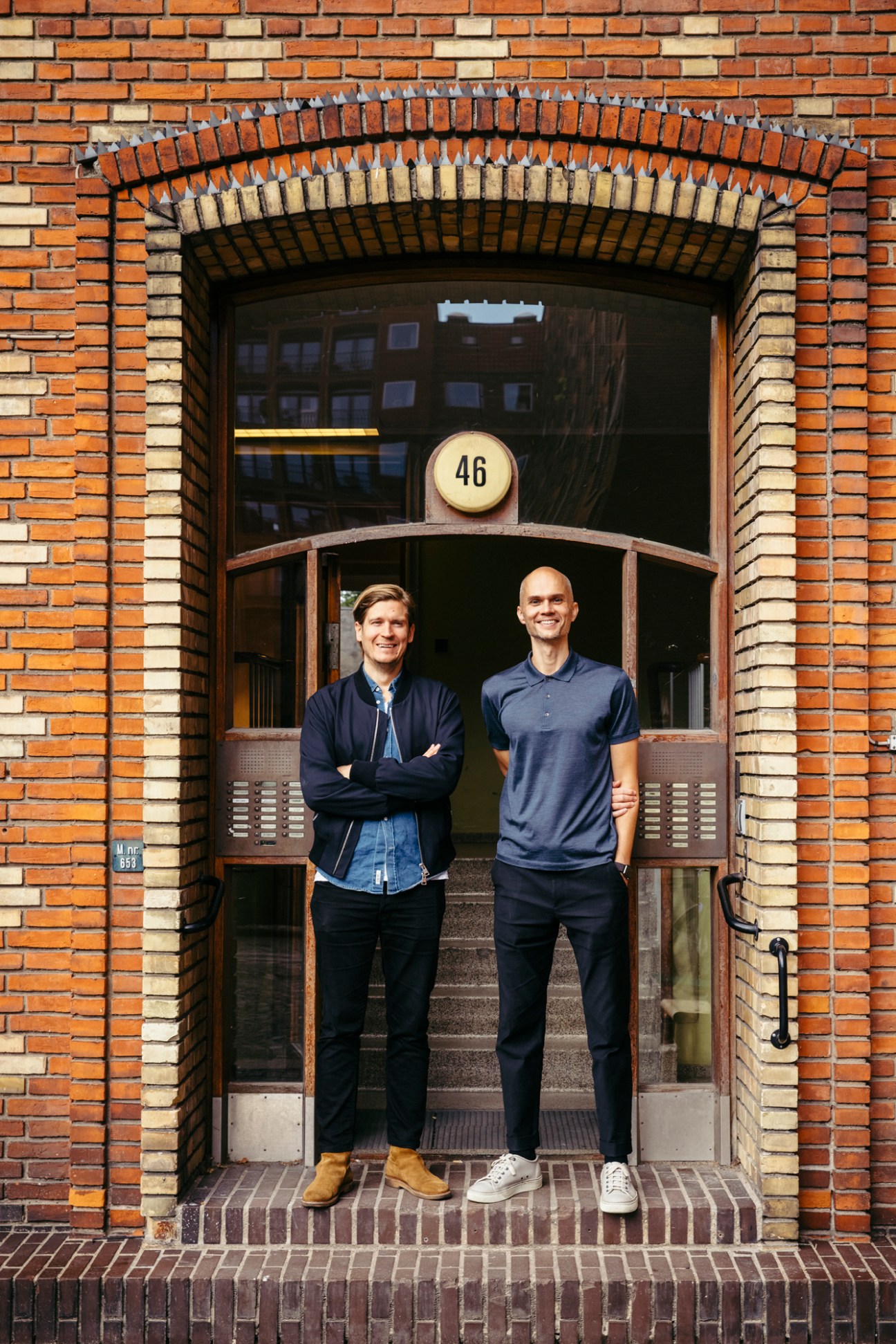 Antti Hirvonen and Miklu Silvanto standing in doorway of brick building