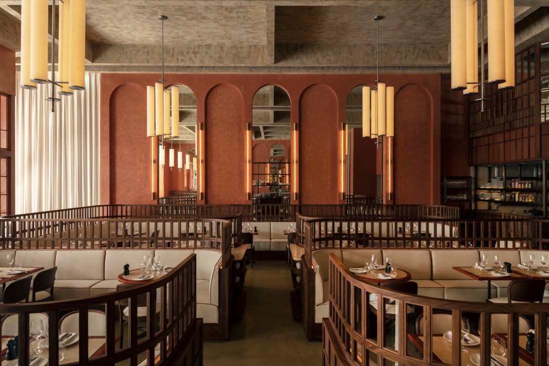 Interior of Maison François restaurant showing beige banquettes, wooden tables, and warm lighting
