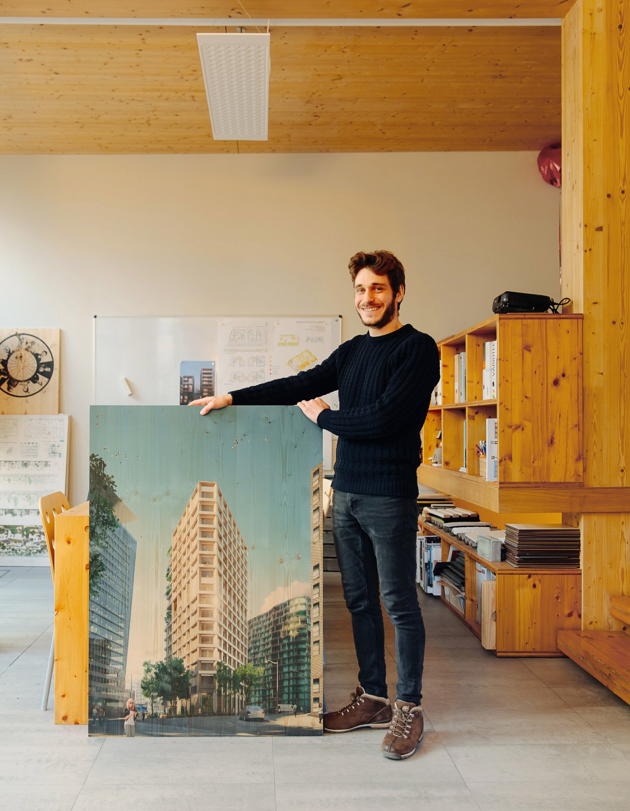 Marc Henri Maxit stands next to an architectural rendering of a timber tower development in Paris