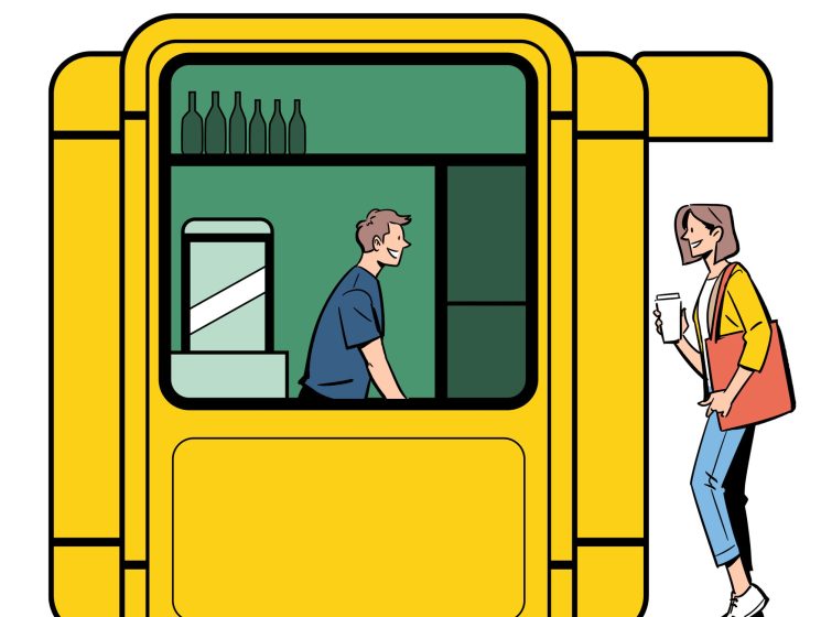 Yellow modernist kiosk with geometric design featuring a vendor inside and customer outside