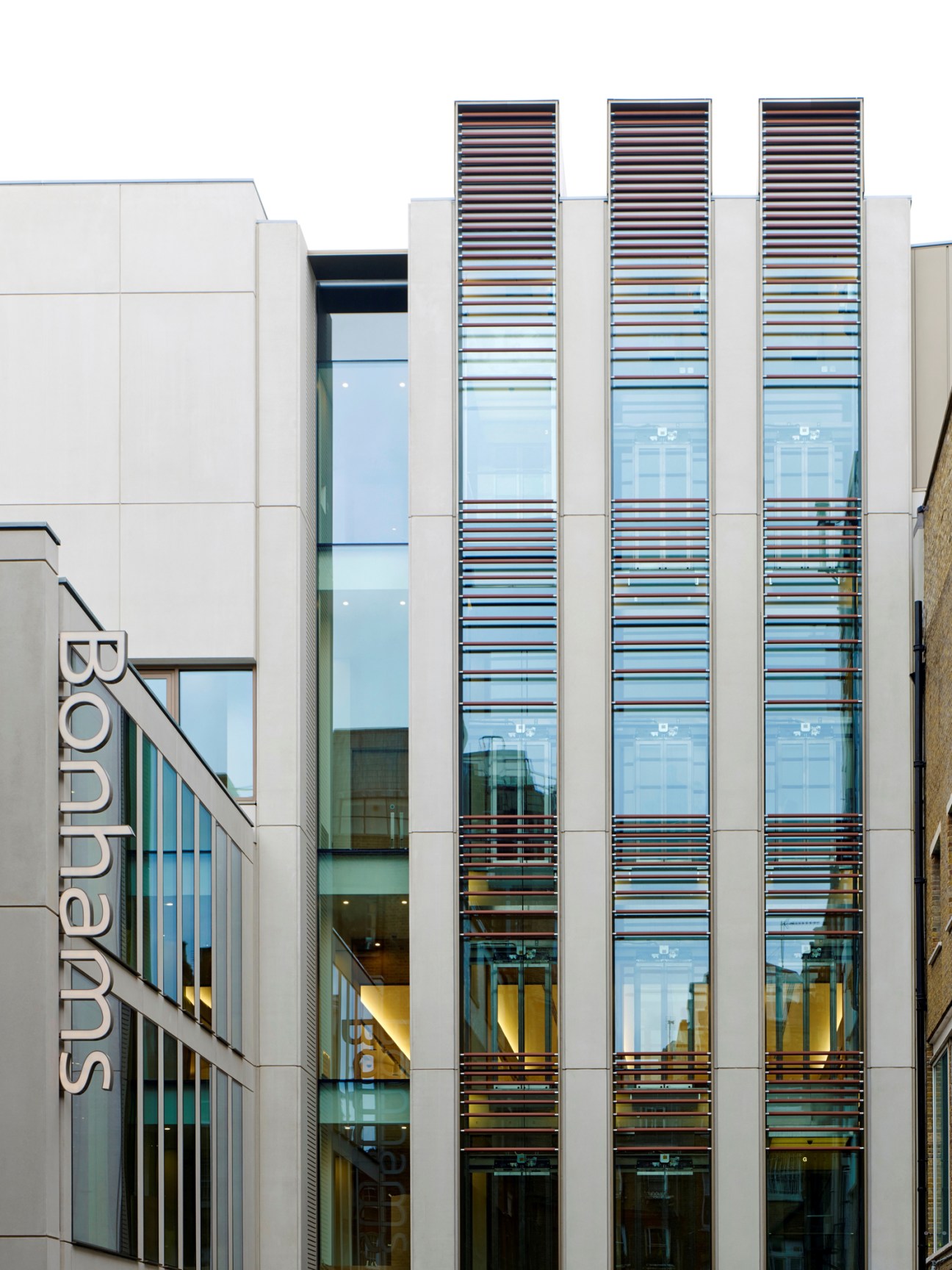 Modern building facade with vertical glass panels and horizontal louvers on Bond Street