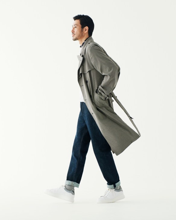 Man in profile wearing Valstar coat, Louis Vuitton jeans, and Emporio Armani trainers.