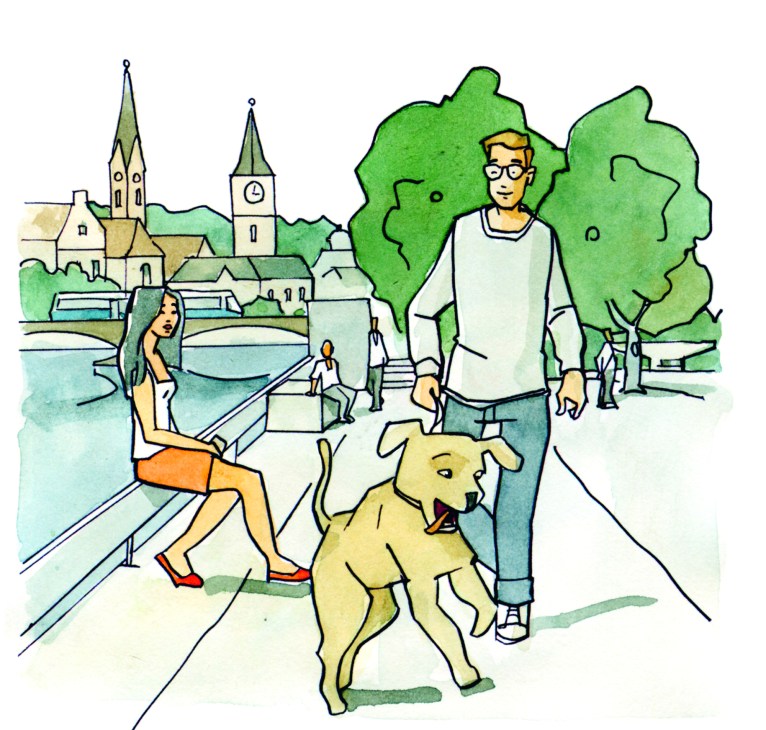 Person in glasses walking with golden dog on tree-lined street with church spires in background