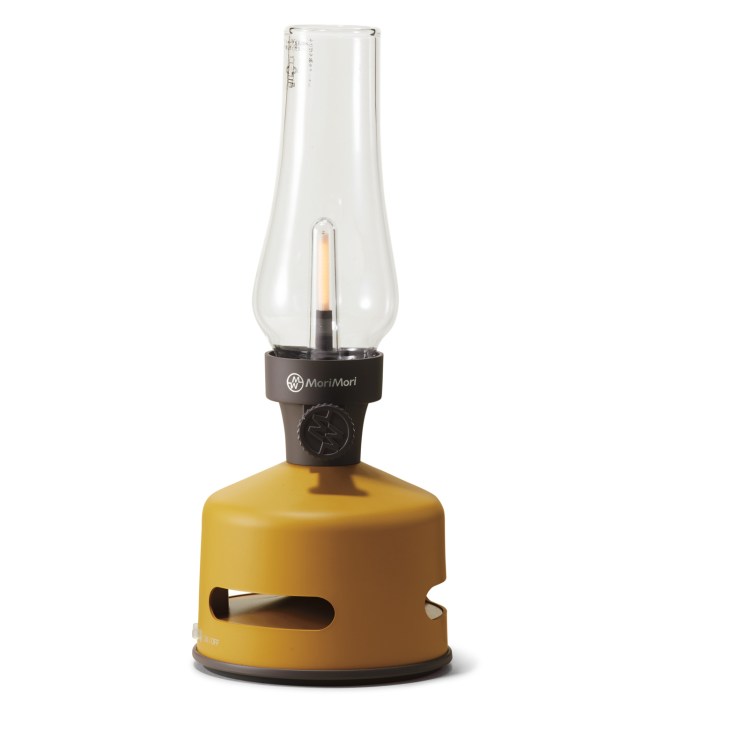 Mori Mori LED lantern speaker with yellow base and clear glass shade with lit candle-style bulb inside.