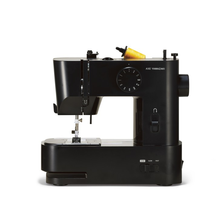 Black Axe Yamazaki sewing machine with yellow thread spool and control dial on white background.