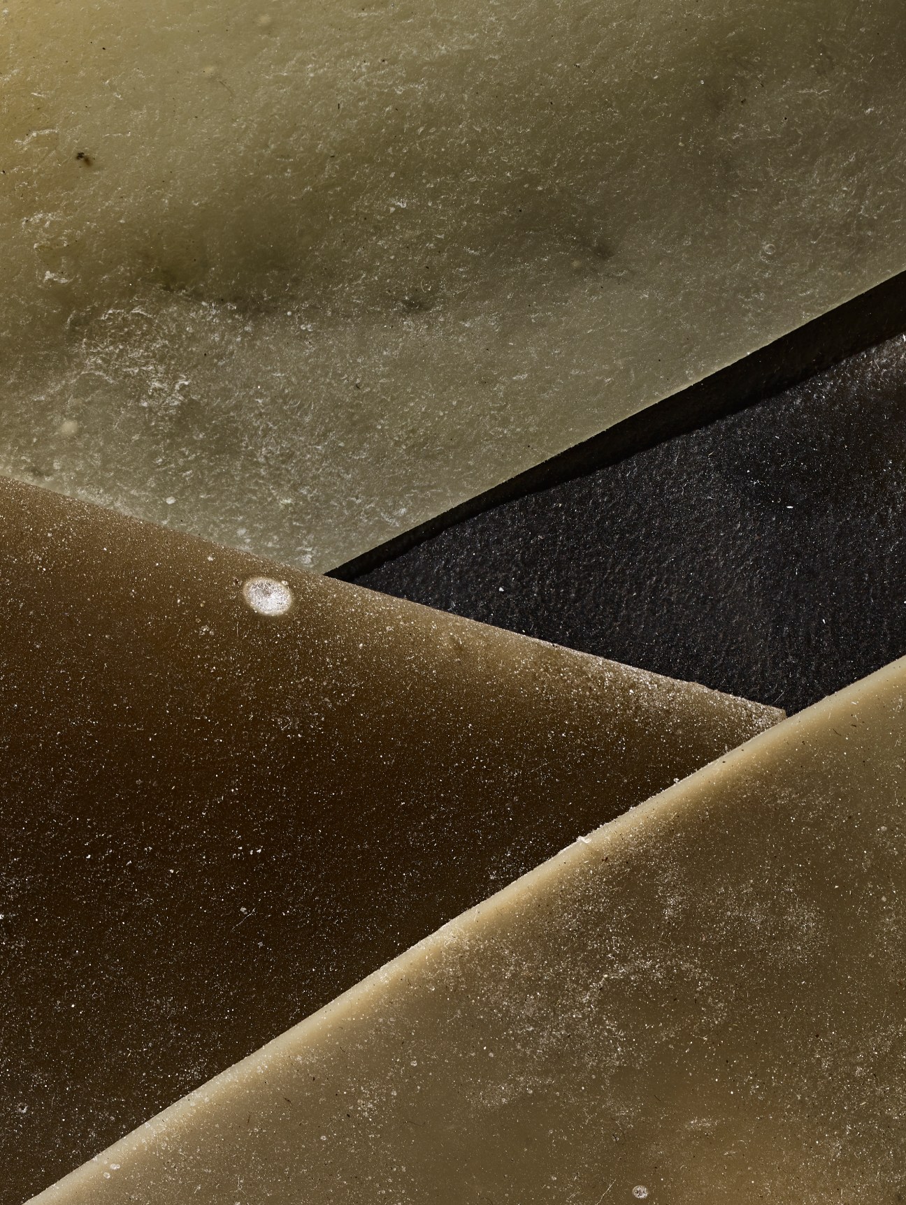 Close-up of layered material samples in earth tones showing textural surfaces with organic, flowing forms
