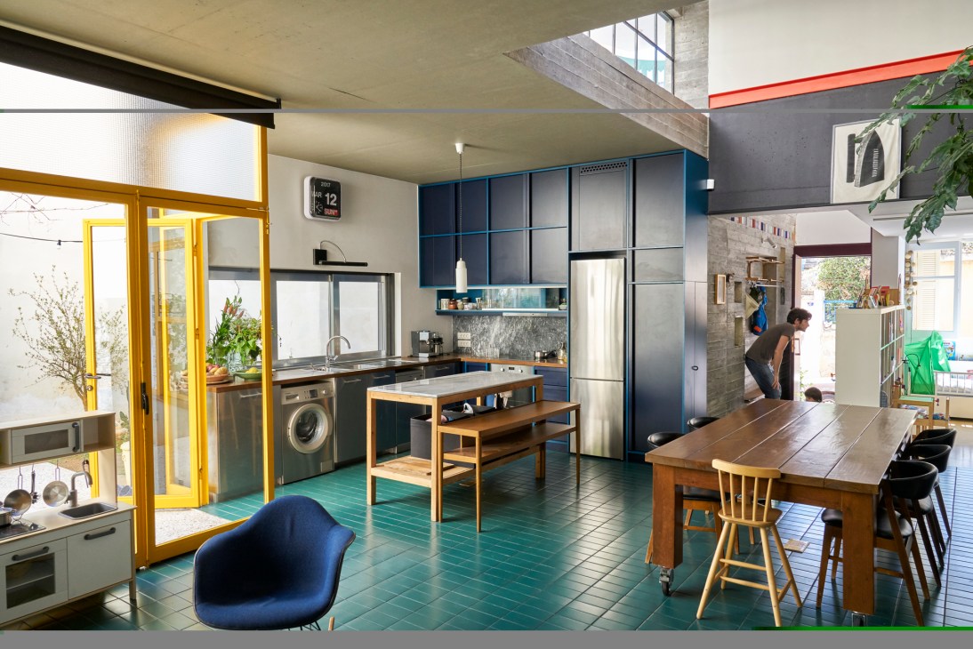 Open-plan kitchen with view to upper floors in Athens home