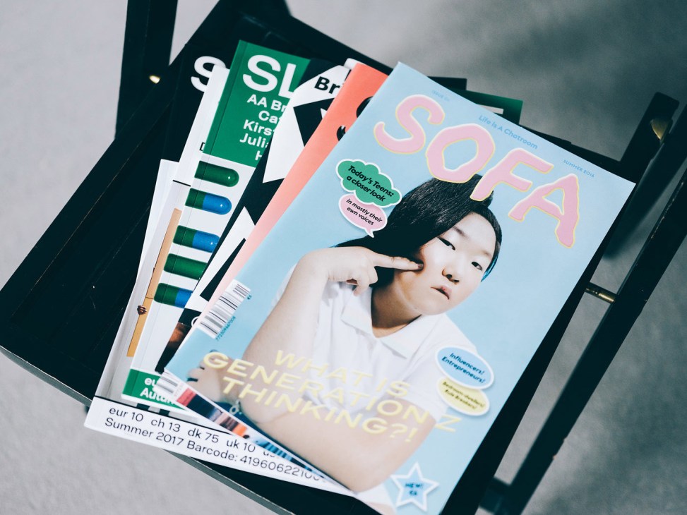 Stack of magazines including Sofa with light blue cover featuring a person and pink typography.