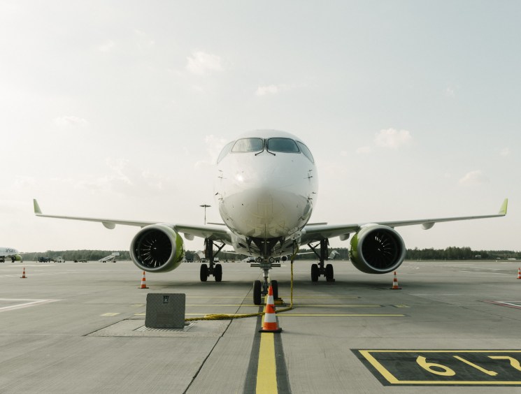 Head-on view of a commercial aircraft parked on the tarmac at an airport.