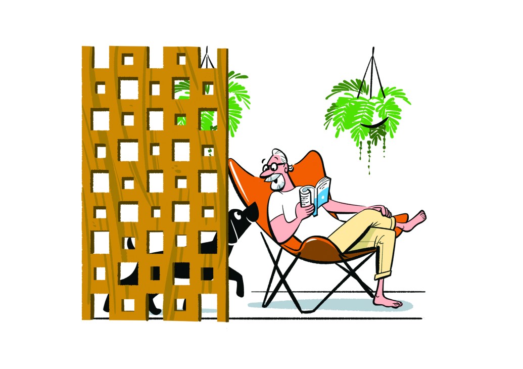 A person reading in an orange chair next to a wooden lattice screen with plants and a cat nearby