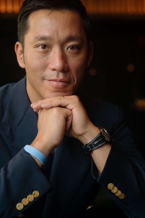 Simon Kim, owner of Cote steakhouse, poses for a portrait wearing a dark blazer and watch.